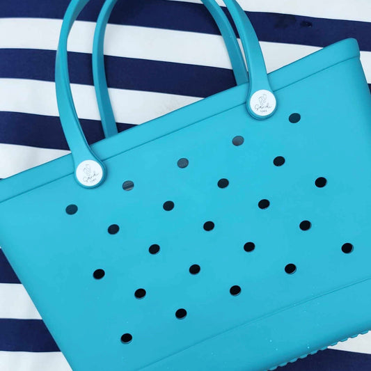 Aqua Marine Silicone Bag: Stylish and Practical for Beach Days. [Durable aqua marine silicone bag rests on a striped background, perfect for carrying beach essentials.]