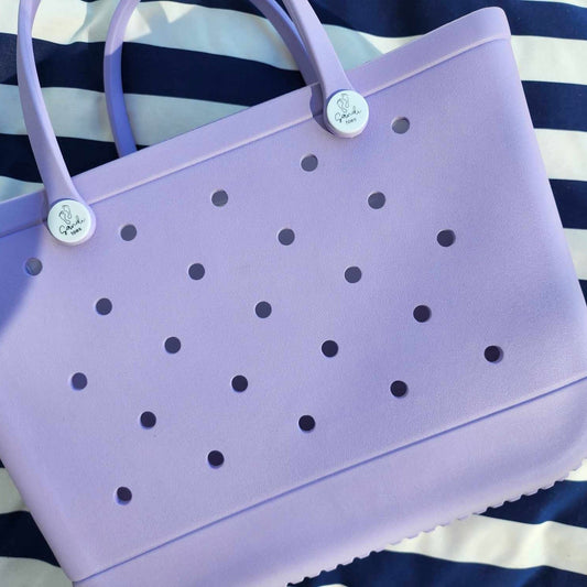 Coral Cove Silicone Bag: Stylish and Practical for Everyday Use. [Durable coral purple silicone bag rests on a striped background, ideal for carrying everyday essentials.]