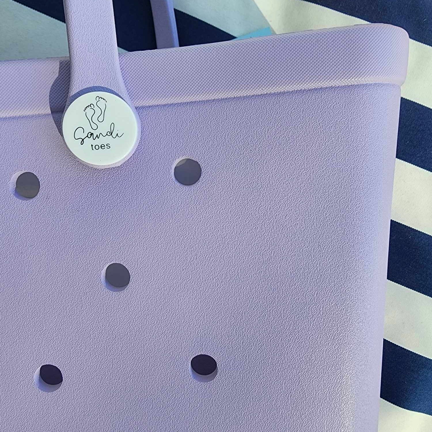 Coral Cove Silicone Bag with Sandi Toes Logo: Everyday Essentials in Style. [Durable coral cove purple silicone bag displays the Sandi Toes logo, ideal for carrying your essentials with a touch of beach flair.]