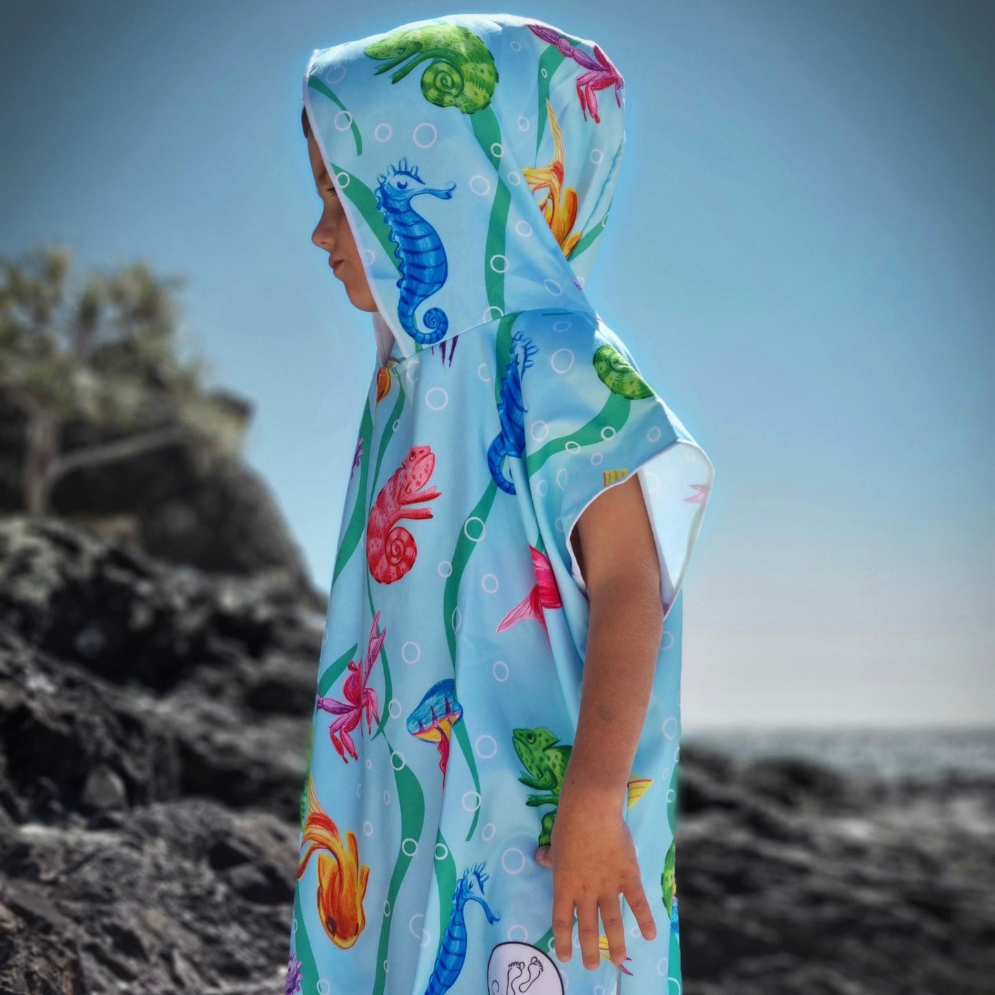 Three year old boy wearing Earth and Sea on the rocks at Currumbin Beach Queensland