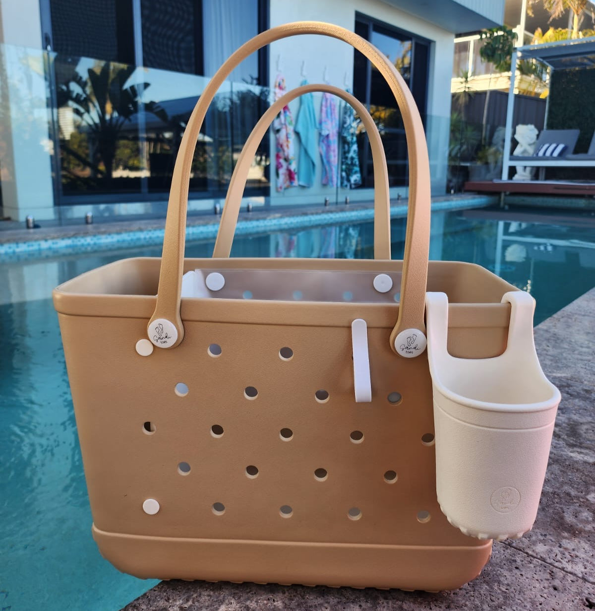 Sand Tote Bag with Silicone Cup holder and key clip beside a swimming pool