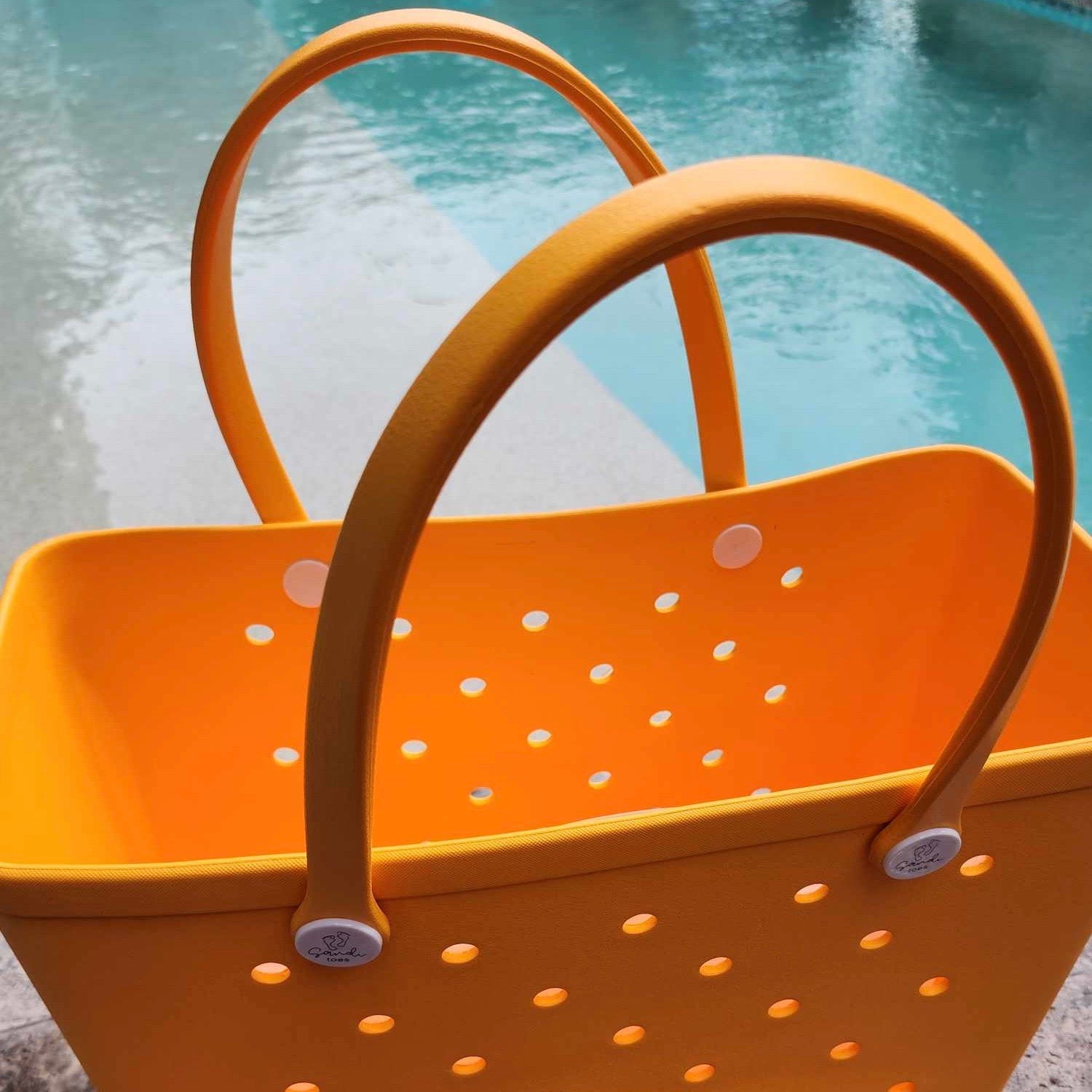 Yellow Summer Bag: Spacious Interior for Poolside Essentials. [Open yellow summer bag sits beside a sparkling pool, revealing a spacious interior perfect for storing towels, sunscreen, and drinks.]