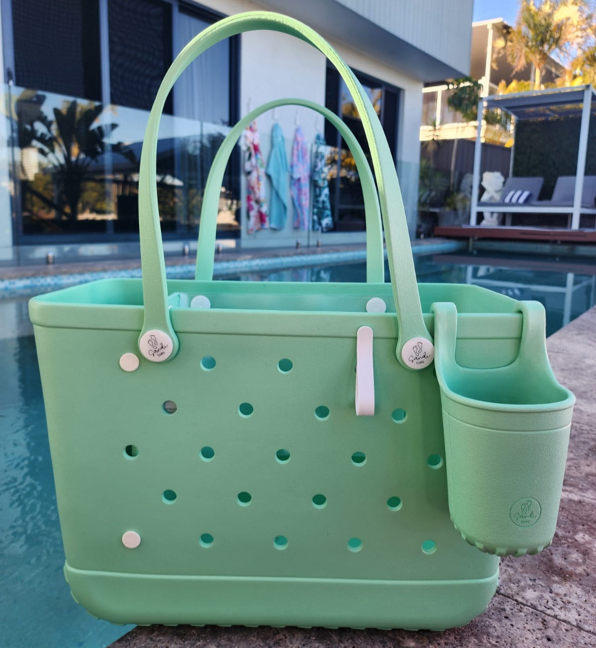 Sea Foam Tote Bag with Silicone Cup holder and key clip beside a swimming pool