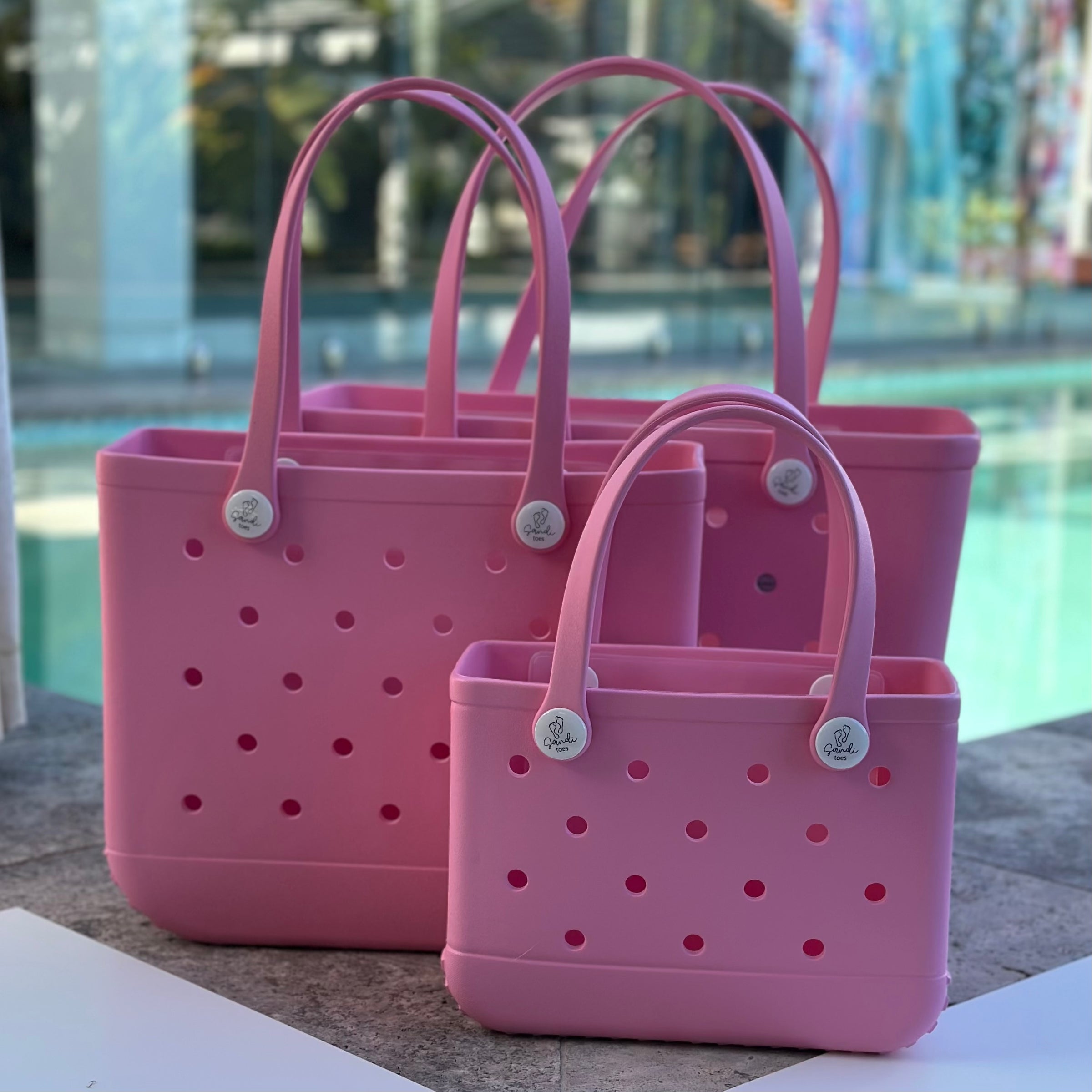 "All three Seashell EVA silicone beach tote bags front view The Hauler, The Everyday and The Mini, showing size, Sandi Toes buttons, and sturdy handles"
