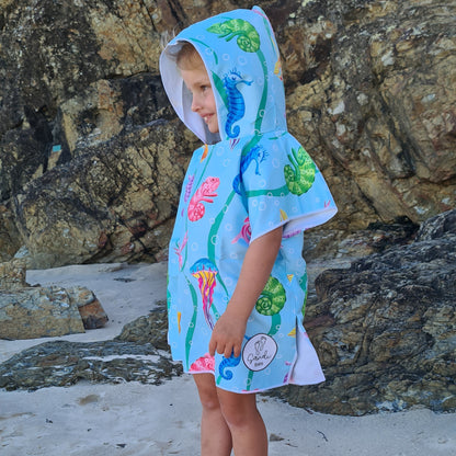 Earth and Sea depicts a three year old on Currumbin Beach with various sea and land animals on the sand free beach hoodie for kids