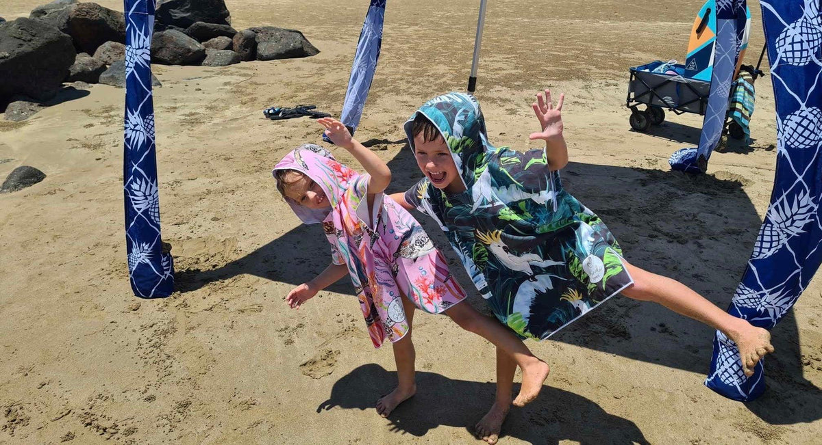 Seen here are our little wonders wearing their sand free hooded sand less beach towels under a Cool Cabanas shade one in Turte Cove the other in a Bird of Paradise, the Turtle Cove also now comes in Large size to fit 6 to 12 year olds