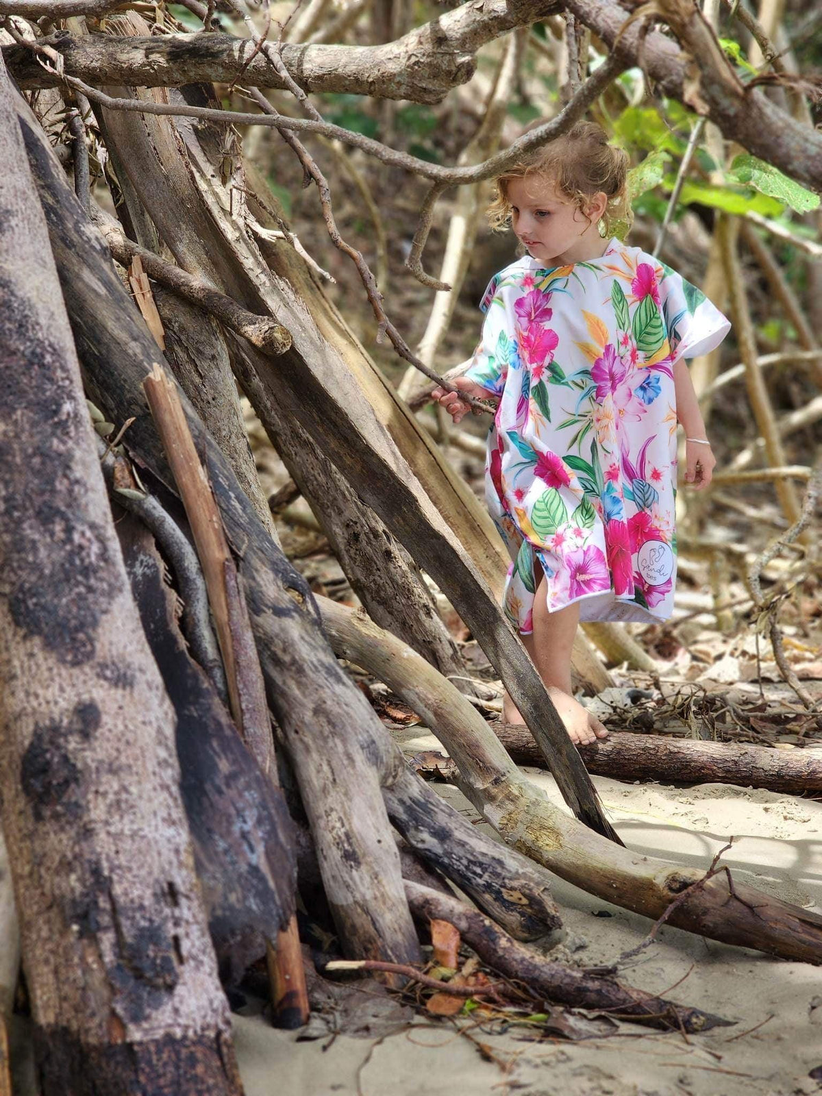 Photo shows a young girl walking between beach trees at currumbin beach queensland