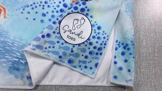 Here is a picture of our Sandi Toes sand free hooded towels showing our logo on a Under the Sea towel