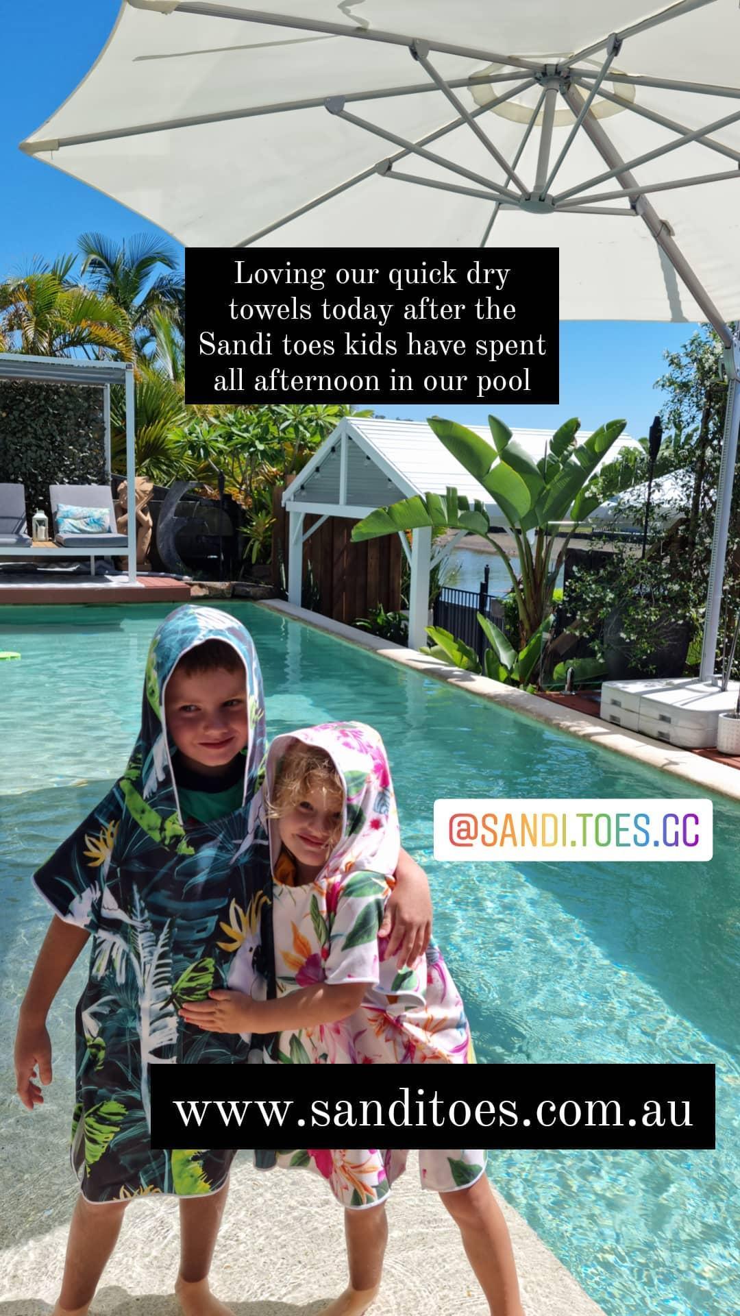 Bird of Paradise and Island Princess sand less hooded towels beside the pool sharing sibling happiness