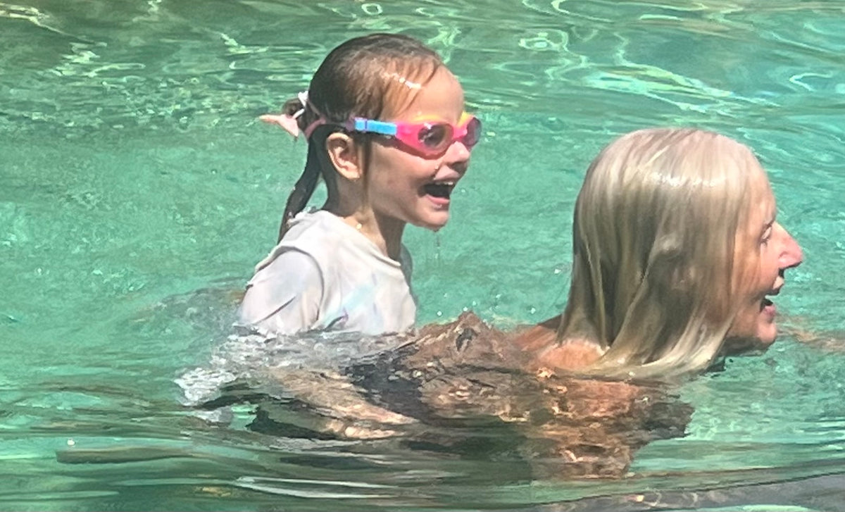 Toddler and Grand Parent having fun learning to swim