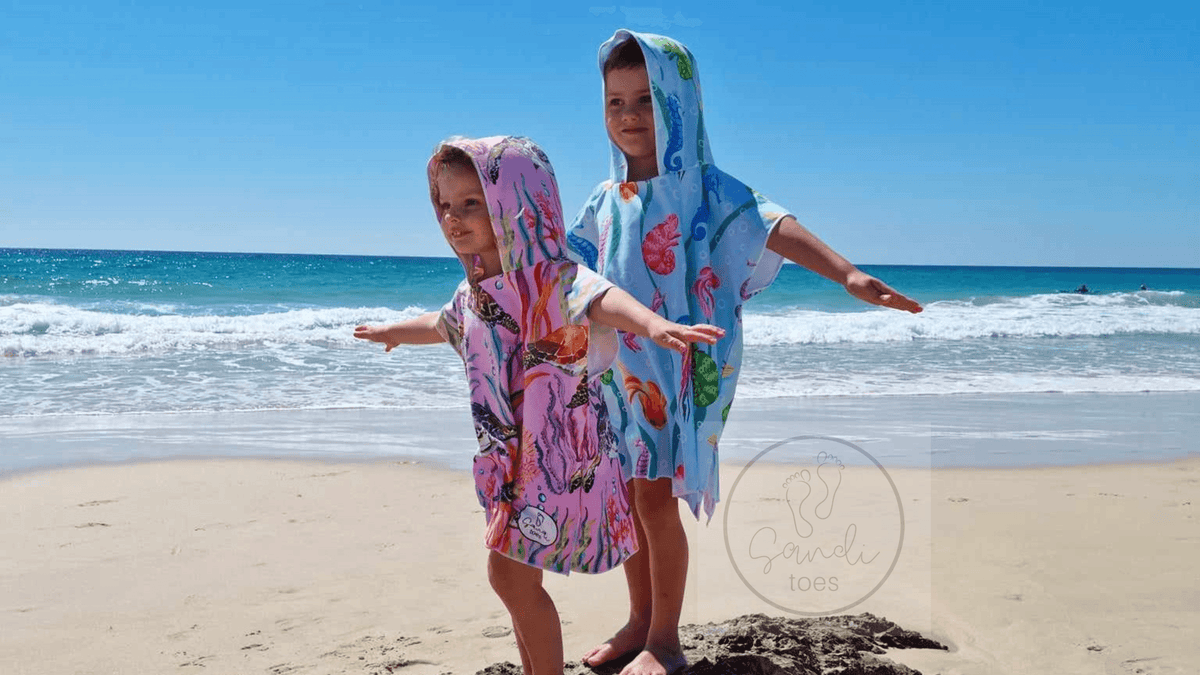Two kids on Currumbin Beach in their Sand Free Hoodies, the girl in Turtle Cove and The Boy in Eath and Sea