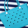 Aqua Marine Silicone Bag: Stylish and Practical for Beach Days. [Durable aqua marine silicone bag rests on a striped background, perfect for carrying beach essentials.]