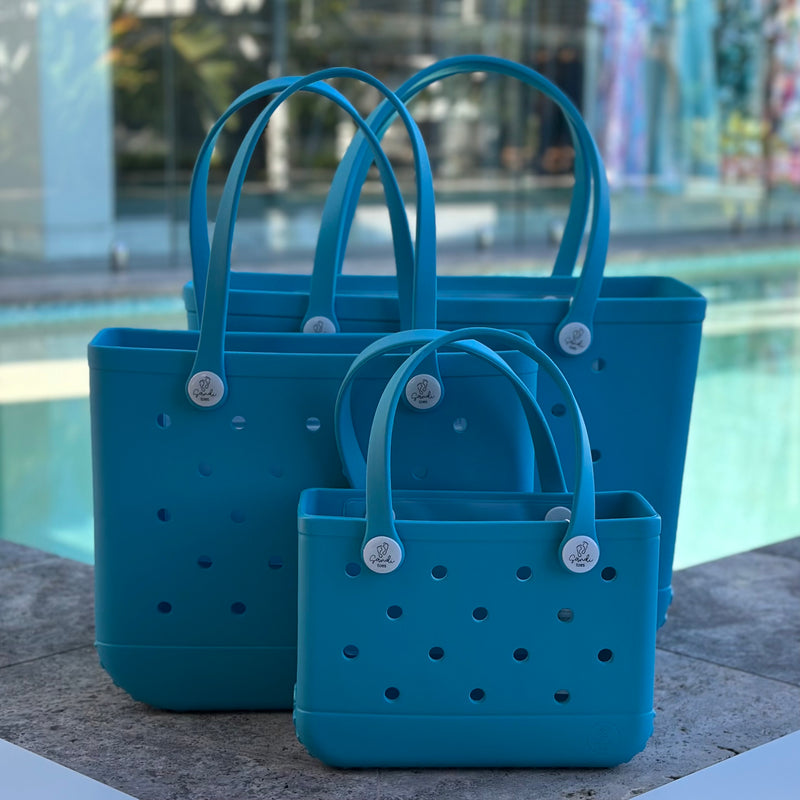  "All three Aqua Marine EVA silicone beach tote bags front view The Hauler, The Everyday and The Mini, showing size, Sandi Toes buttons, and sturdy handles"