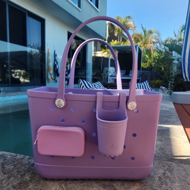 Purple tote bag with cup holder and pouch by a poolside