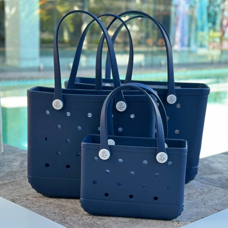* "All three Sailors Navy EVA silicone beach tote bags front view The Hauler, The Everyday and The Mini, showing size, Sandi Toes buttons, and sturdy handles"