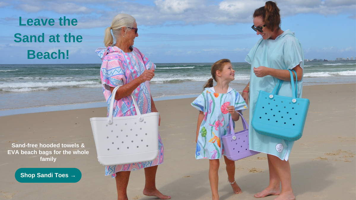 Three generations on the beach wearing Sandi Toes sand-free hooded towels and carrying EVA beach bags