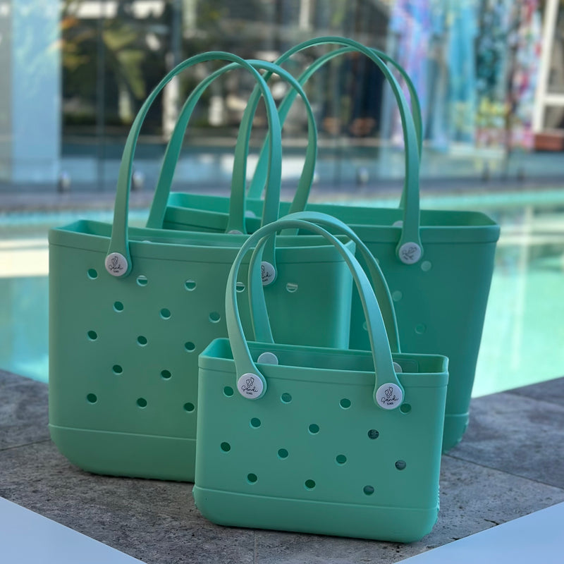 "All three Sea Foam EVA silicone beach tote bags front view The Hauler, The Everyday and The Mini, showing size, Sandi Toes buttons, and sturdy handles"
