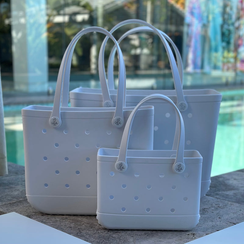 * "All three White Haven EVA silicone beach tote bags front view The Hauler, The Everyday and The Mini, showing size, Sandi Toes buttons, and sturdy handles"