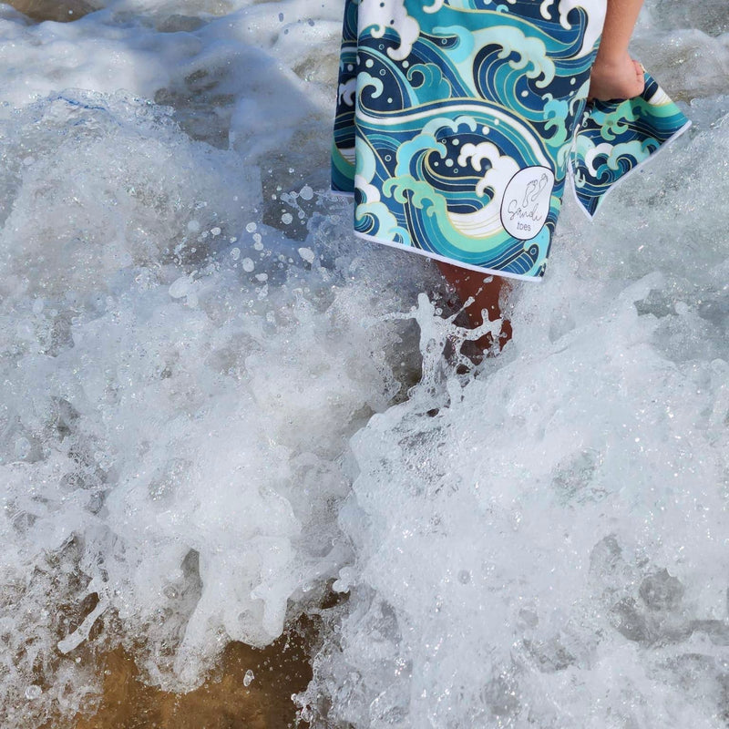 Wipeout wading in the ocean showing sandi toes logo 