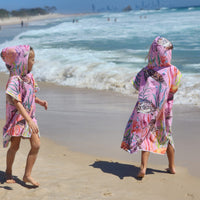 Two girls in turtle cove hoodies. one in medium size one in smal size