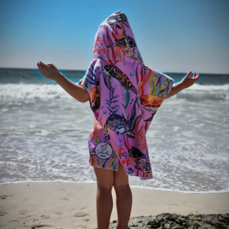 Sandi Toes sand free beach towels depicts this 3 year old girl standing  on a rock at Currumbin beach Queensland in her Turlte Cove  